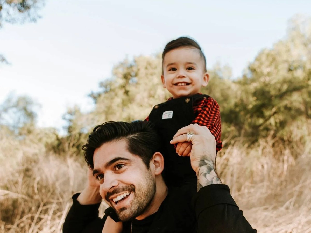 Father carrying his young son outdoors, the kind of family outcome family law firms fight for