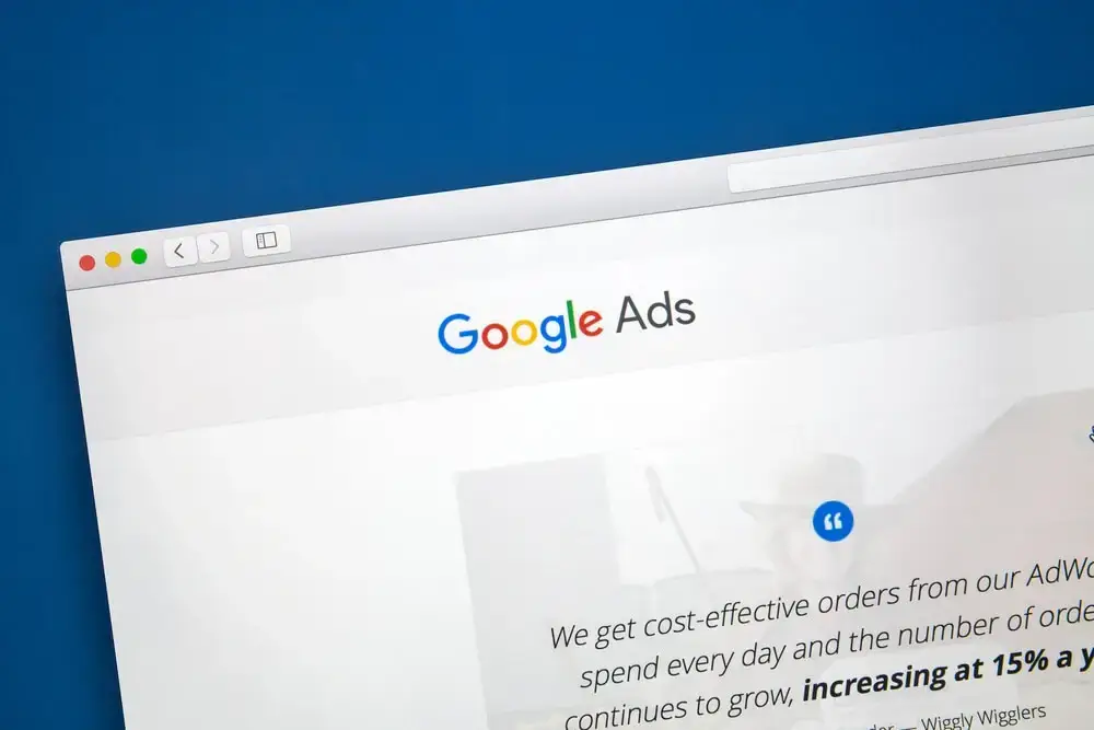 A magnifying glass hovering over a bar chart and Google Ads interface, showing 5 proven ways to improve Google Ads Quality Score
