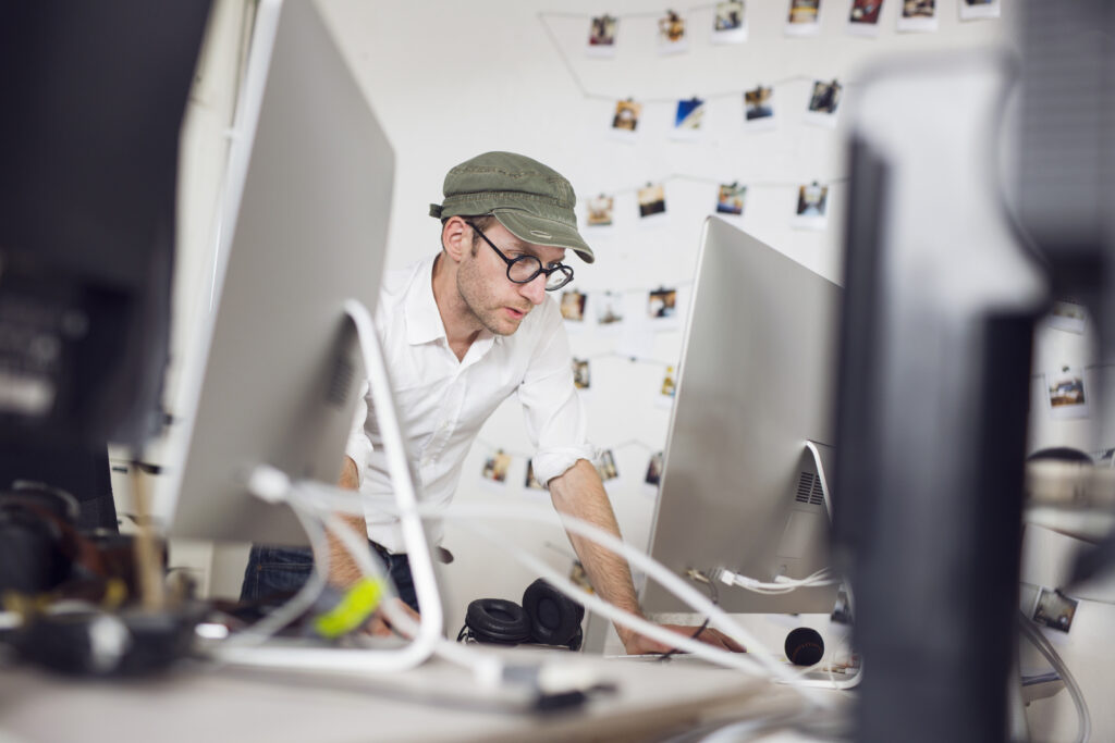 A magnifiying glass scans over charts and graphs on a laptop screen, emphasizing the detailed analysis involved in an SEO audit