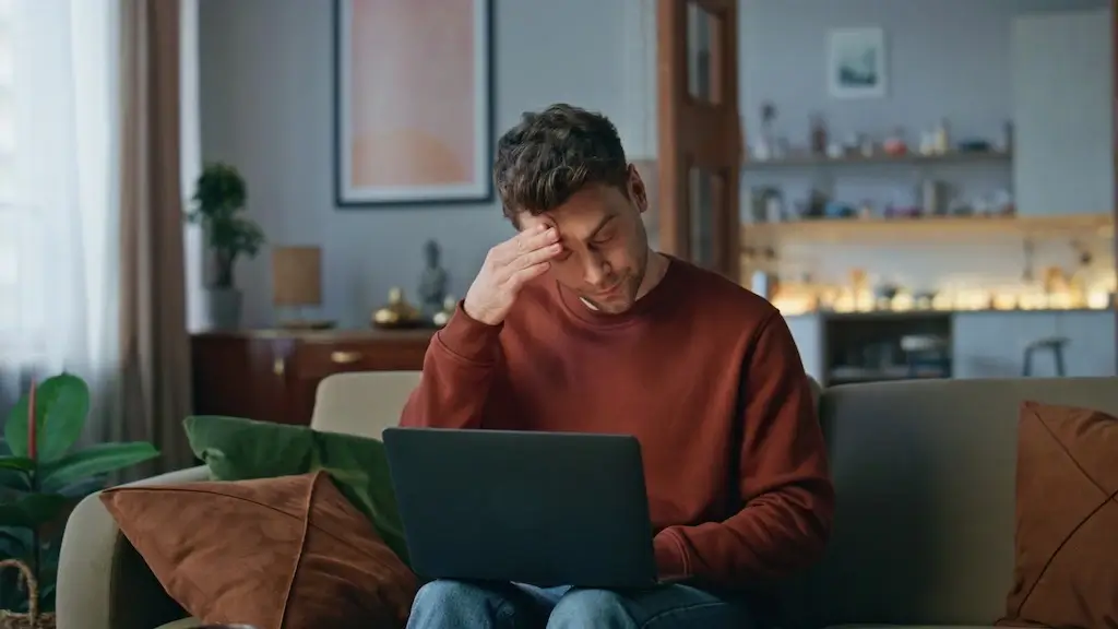 A marketer looking stressed, surrounded by tangled wires, monitors with charts, and a large red "stop" sign to symbolize SEO mistakes