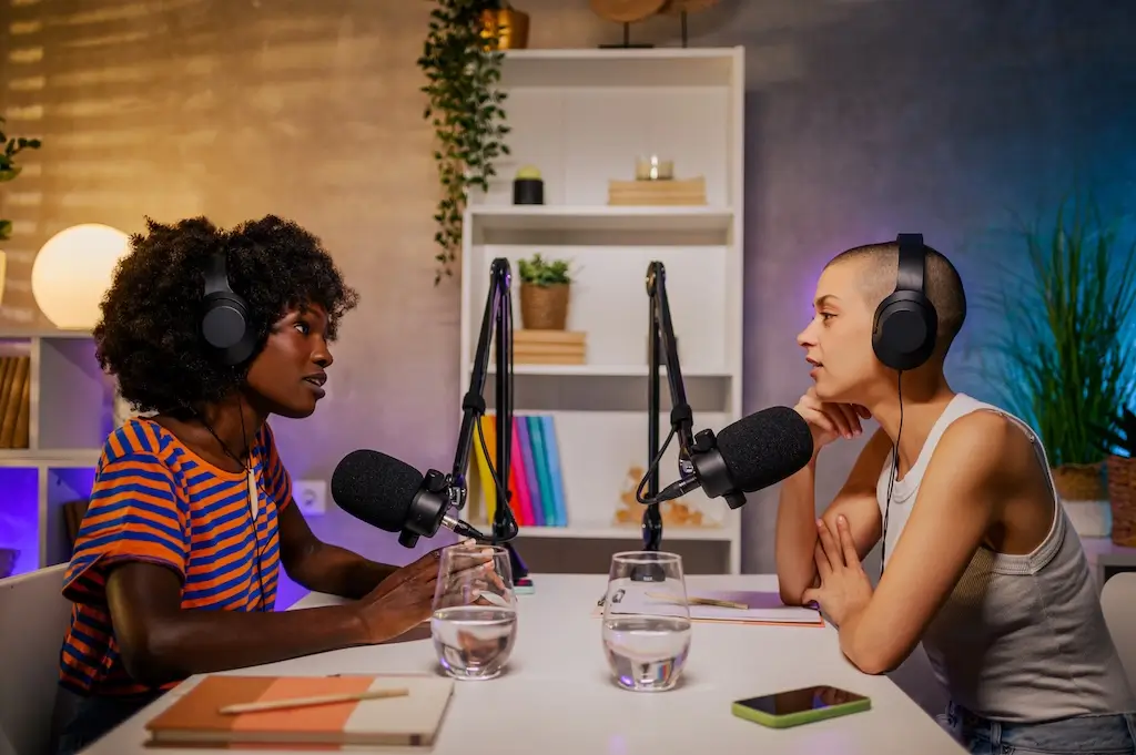 A collection of podcast microphones and headphones on a desk, representing the top digital marketing podcasts