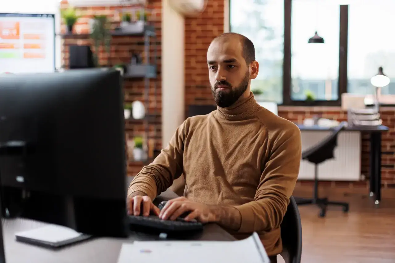 Man at a digital marketing agency desk researching what is a digital marketing agency.